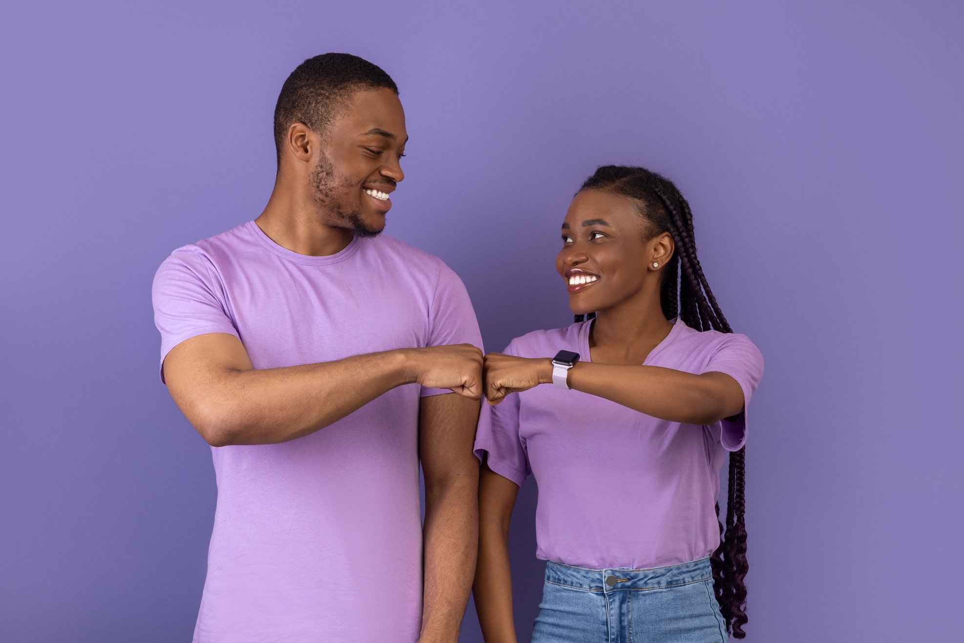 Portrait of happy black couple celebrating win bumping fists